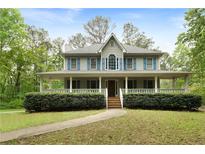 Charming two-story home with a welcoming front porch and lush landscaping at 569 Hale Mountain Ct, Hiram, GA 30141