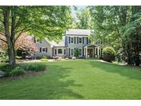 Charming gray brick home with a lush green lawn and mature trees in a desirable neighborhood at 4586 Smoke Rise Ln, Marietta, GA 30062