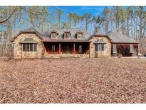 Inviting stone facade of a charming home featuring a covered front porch and dormer windows at 4220 Chapel Hill Farms Dr, Douglasville, GA 30135