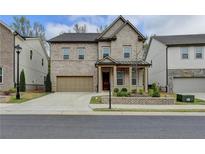 Charming two-story brick home featuring a well-manicured lawn, attached two-car garage, and welcoming front porch at 4391 Encore Blvd, Duluth, GA 30097