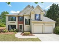 Charming two-story home with a two-car garage, complemented by lush greenery and a well-manicured lawn at 1745 Fairburn Dr, Cumming, GA 30040
