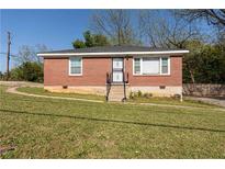 Charming brick home with a well-maintained lawn, inviting curb appeal, and a secure front entrance at 2576 Flat Shoals Dr, Decatur, GA 30034