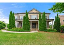 Elegant stone facade home with manicured lawn and symmetrical landscaping exudes curb appeal at 3810 Sweat Creek Run, Marietta, GA 30062