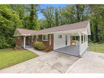 Charming brick home with a covered carport, landscaped yard, and newly painted white wood accents at 3471 Elgin Dr, Decatur, GA 30032