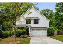 Charming two-story home featuring a white exterior, attached garage, and well-manicured landscaping at 1378 Lochland Se Rd, Atlanta, GA 30316