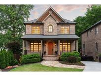 Charming two-story brick home featuring a covered front porch and manicured landscaping at 2017 Harts Mill Ne Rd, Chamblee, GA 30341