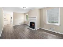 Spacious living room featuring a fireplace, wood floors, and natural light from several windows at 2771 Dresden Trl, Atlanta, GA 30344