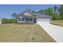 Charming single-story home featuring a two-car garage, gray siding, and a well-manicured front lawn at 707 Ralph Still Rd, Dacula, GA 30019