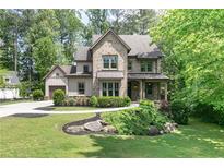 Charming two-story brick home featuring a well-manicured lawn and inviting front porch, perfect for relaxation at 610 Valley Green Trce, Marietta, GA 30068