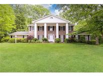 Classic brick home with large white columns, black shutters, and well-manicured lawn at 295 Glen Lake Dr, Atlanta, GA 30327