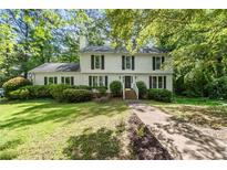 Charming two-story home with black shutters, landscaped yard, and a walkway leading to the front door at 411 Woodstone West Dr, Marietta, GA 30068