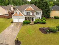 Charming two-story home with a manicured lawn, lush landscaping, and a two-car garage at 120 Clifford Ct, Canton, GA 30115