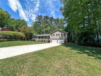 Landscaped home with a lush lawn, two-car garage, and inviting covered front porch at 3075 Nuthatch Nw Ct, Kennesaw, GA 30144