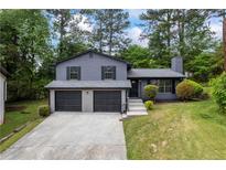 Charming two-story home with a two-car garage, nestled among mature trees at 2246 Hightrail Ct, Lithonia, GA 30058