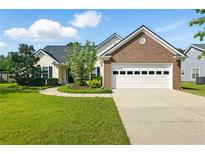Charming one-story home with a manicured lawn, brick accents, and a two-car garage provides curb appeal at 2487 Battery Pointe, Lawrenceville, GA 30043