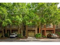 Charming townhome showcasing brick facade, private garages, and beautifully landscaped front yard with mature trees at 732 Province Se Pl, Atlanta, GA 30312