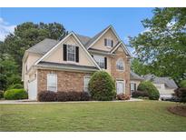 Charming two-story home with stone accents, manicured lawn, and lush landscaping at 113 Glenmore Ln, Mcdonough, GA 30253