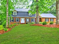 Inviting brick home featuring a lush green lawn and mature trees offering plenty of shade at 1257 Independence Way, Marietta, GA 30062