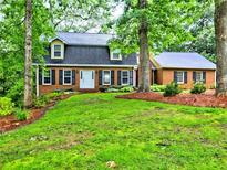 Traditional brick home with a lush green front yard, mature trees, and a welcoming entrance at 1257 Independence Way, Marietta, GA 30062