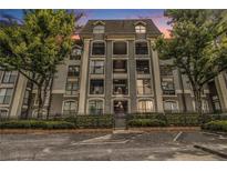 Beautiful condo building exterior with balconies, secure gate, and lush green landscaping at 2657 Lenox Ne Rd # C38, Atlanta, GA 30324
