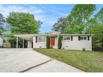 Charming single-story home with red front door, covered parking and fresh landscaping at 4004 Knightsbridge Nw Rd, Kennesaw, GA 30144