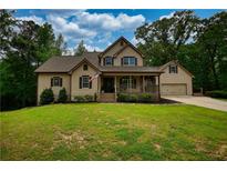 Charming two-story home with a covered front porch and a well-manicured lawn at 547 Ellington Rd, Oxford, GA 30054