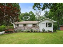 Charming single-story white brick home with a manicured lawn and beautiful landscaping at 1221 Oakfield Se Dr, Atlanta, GA 30316