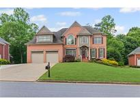 Beautiful brick two-story home featuring a well-manicured front lawn and a two-car garage at 3341 Cranmore Chase, Marietta, GA 30066