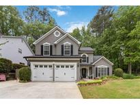 Charming two-story home featuring a two-car garage, manicured lawn and lush landscaping at 2849 Beddington Way, Suwanee, GA 30024