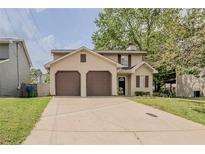 Two-story home featuring a two-car garage, neutral siding, and a well-maintained front lawn at 6351 Stablewood Way, Lithonia, GA 30058