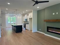 Open-concept living room with a modern fireplace and seamless flow into the adjacent kitchen at 1932 Appian Aly, Kennesaw, GA 30144