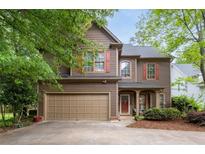 Charming two-story home features brown siding, red shutters and a two car garage at 238 Ivy Glen Cir, Avondale Estates, GA 30002