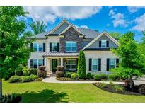 Beautiful two-story brick home with a well-manicured lawn, stone accents, and black shutters at 3755 Valleyway Rd, Cumming, GA 30040