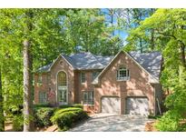 Beautiful two-story brick home with mature trees, well-maintained landscaping, and an attached two-car garage at 4295 Parish Trce, Marietta, GA 30066