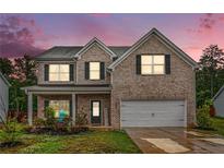 Charming two-story brick home with well-maintained landscaping and a two-car garage at 328 Orchid Dr, Mcdonough, GA 30252