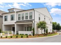 Beautifully landscaped two-story home with a covered porch and white picket fence exudes charm at 613 Stickley Oak Way, Woodstock, GA 30189