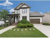 Charming two-story home featuring a welcoming front porch, well-manicured lawn, and an attached two-car garage at 215 Haleys Ct, Woodstock, GA 30188