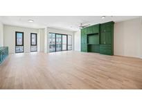 Bright, open living room featuring wood floors, balcony access, and a custom green entertainment center at 1100 Howell Mill Nw Rd # 505, Atlanta, GA 30318