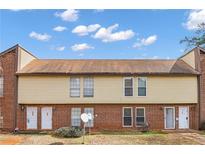 Charming townhome featuring brick and vinyl siding under a blue sky with fluffy clouds at 3162 Citrus Ct, Decatur, GA 30034