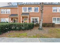 Brick townhomes with well-maintained landscaping and mature trees at 4418 Chowning Way, Dunwoody, GA 30338