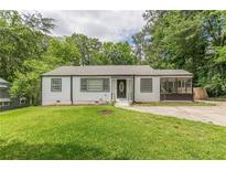 Charming single-story home featuring a well-manicured lawn and a screened-in porch at 3311 Lavista Dr, Hapeville, GA 30354