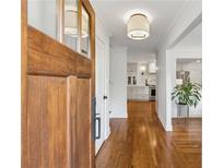 Inviting foyer with hardwood floors, light fixture, and views into the kitchen and living spaces at 3772 Evans Rd, Atlanta, GA 30340