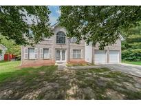 Charming two-story brick home featuring an attached two car garage at 1528 Rogers Crossing Dr, Lithonia, GA 30058