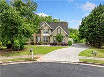Charming two-story home featuring a well-manicured lawn, mature trees, and a spacious driveway at 209 Braemar Ct, Mcdonough, GA 30253
