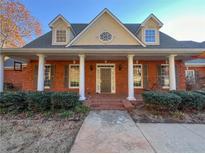 Charming brick home featuring a covered front porch with stately columns and dormer windows at 3212 Woodhaven Sw Ct, Conyers, GA 30094