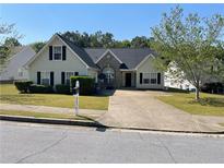 Charming single-Gathering home featuring a well-maintained front yard, a symmetrical design, and an inviting entrance at 2436 Moultrie Ct, Dacula, GA 30019