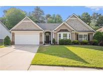 Charming home featuring a well-manicured lawn, attached garage, and inviting curb appeal at 352 Southgate Dr, Locust Grove, GA 30248