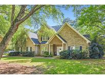 Charming brick home featuring a manicured lawn and mature trees, showcasing classic curb appeal at 595 Mcgarity Dr, Mcdonough, GA 30252