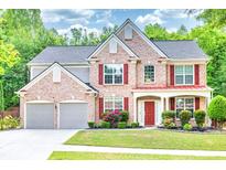 Charming two-story brick home with a well-manicured lawn and two-car garage at 5008 Bethpage Dr, Suwanee, GA 30024