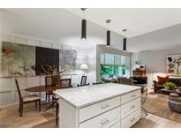 Open-concept kitchen with stone countertops, modern lighting, and adjacent dining and living areas at 2632 Peachtree Nw Rd # 203B, Atlanta, GA 30305